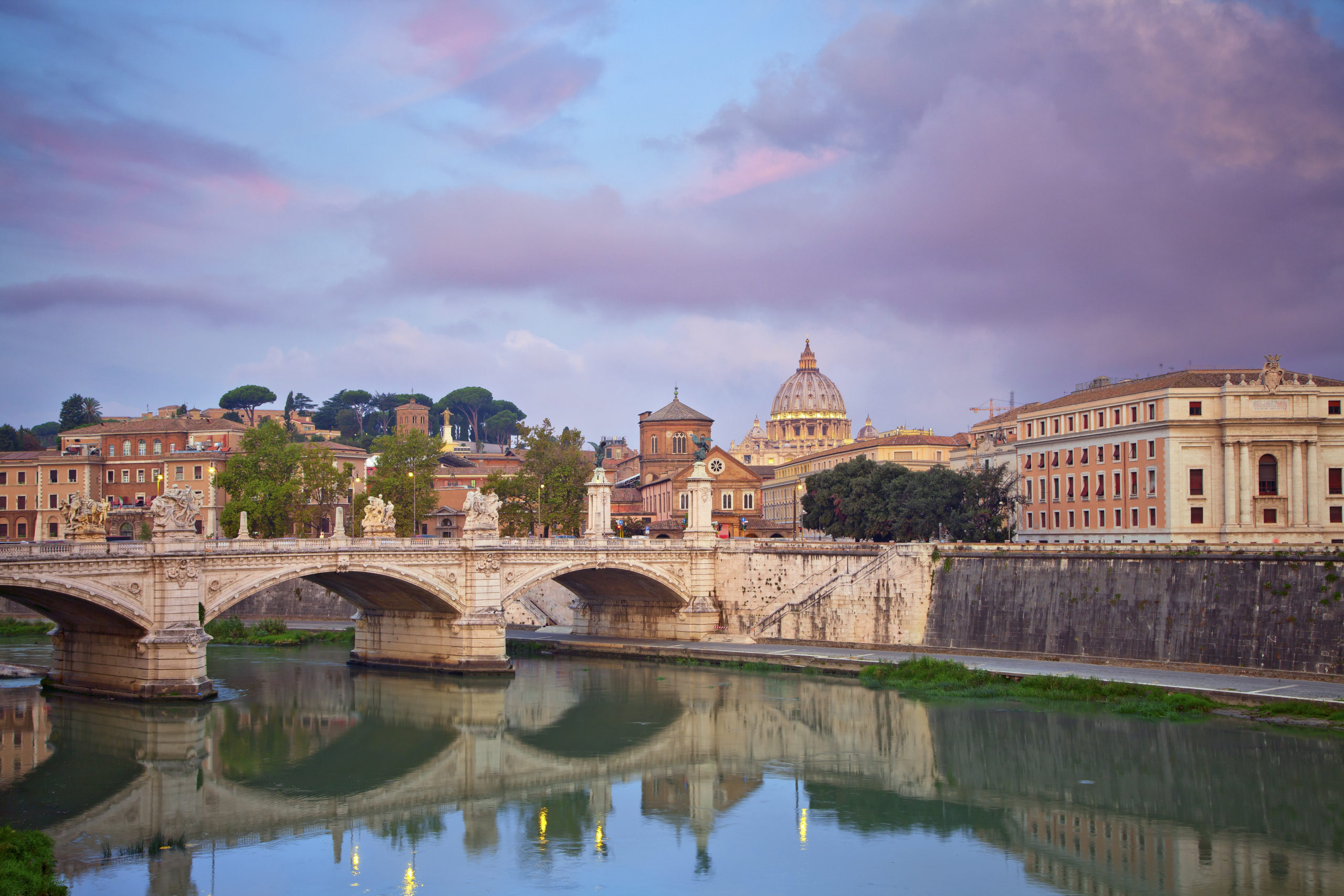 View of Vittorio Emanuele Bridge and the St. Peter's cathedral in Rome, Italy during beautiful sunrise.